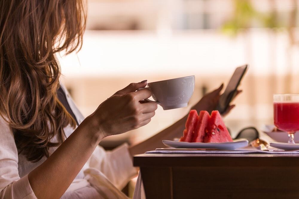 Vogal Luxury Beach Hotel&SPA Natal Exterior foto A woman drinking coffee